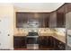 Well-lit kitchen featuring stainless steel appliances and dark wood cabinets at 71 Potted Plant Ct, Clayton, NC 27520