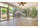 Bright sunroom featuring tile floors, ceiling fan, and many windows overlooking mature landscaping at 71 Potted Plant Ct, Clayton, NC 27520