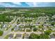 A wide aerial shot shows a neighborhood filled with green trees and numerous homes under a partly cloudy sky at 7109 Spanglers Spring Way, Raleigh, NC 27610