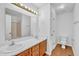 Bright bathroom features double sinks, wood floors, and a framed mirror with lighting at 7109 Spanglers Spring Way, Raleigh, NC 27610