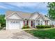 Inviting one-story home with an attached garage, manicured lawn, and lovely curb appeal at 7109 Spanglers Spring Way, Raleigh, NC 27610