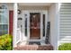 Close-up of the front door and entry featuring a welcome sign and brick-laid porch at 7109 Spanglers Spring Way, Raleigh, NC 27610