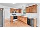 Well-lit kitchen featuring a range, microwave, and stainless steel fridge at 7109 Spanglers Spring Way, Raleigh, NC 27610