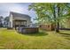 Spacious backyard featuring a pool, shed, covered deck area, and lush green lawn, perfect for outdoor enjoyment at 827 Lockesley Ln, Burlington, NC 27217