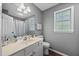 Bright bathroom with a single sink, vanity, toilet, and a window for natural light at 827 Lockesley Ln, Burlington, NC 27217