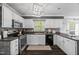 Bright kitchen features white cabinets, stainless appliances, tile backsplash, and a garden view window at 827 Lockesley Ln, Burlington, NC 27217
