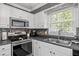 Bright kitchen with stainless steel appliances, gray countertops, a stainless steel sink, and a stylish tile backsplash at 827 Lockesley Ln, Burlington, NC 27217