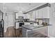 Charming kitchen with white cabinetry, gray backsplash, dark countertops, and a stylish lighting fixture at 827 Lockesley Ln, Burlington, NC 27217