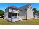Back exterior of home showcasing a screened porch and light siding, providing a cozy outdoor living space at 1009 Sarazen Dr, Clayton, NC 27527