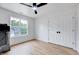 Bright bedroom features wood floors, a ceiling fan, a large window, and a closet at 1009 Sarazen Dr, Clayton, NC 27527