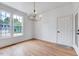 Charming dining room with hardwood floors, elegant chandelier, and large windows offering neighborhood views at 1009 Sarazen Dr, Clayton, NC 27527