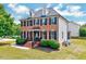 Angle view of a traditional home showcasing brick facade, side siding, and a well-maintained lawn at 1009 Sarazen Dr, Clayton, NC 27527