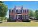 Charming two-story red brick home featuring black shutters, dormer windows, and well-maintained landscaping at 1009 Sarazen Dr, Clayton, NC 27527