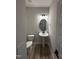 Powder room features modern fixtures, pedestal sink, and an oval mirror at 1010 Westerland Way # 200, Durham, NC 27703