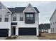 Charming two-story townhome features a painted brick facade, black garage door, and neutral siding accents at 1010 Westerland Way # 200, Durham, NC 27703