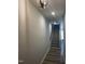 Hallway with hardwood floors leads to carpeted stairs with white risers and gray treads at 1010 Westerland Way # 200, Durham, NC 27703