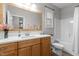 Bright bathroom featuring a wooden framed mirror, white countertops and wood cabinets at 105 Oak Ridge Rd, Franklinton, NC 27525