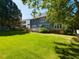 Spacious backyard featuring lush green lawn, mature trees, and the home's back exterior at 1106 Purple Glory Dr, Apex, NC 27502