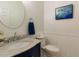 Elegant powder room featuring a round mirror, marble countertop and beadboard paneling at 1106 Purple Glory Dr, Apex, NC 27502
