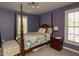 This cozy bedroom features a four poster bed, bedside table and lamp, and lots of natural light at 1106 Purple Glory Dr, Apex, NC 27502