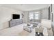 Bright living room featuring a comfortable gray sectional sofa and a marble-topped coffee table at 1112 Landen Creek Ln, Zebulon, NC 27597