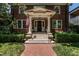 Charming brick home with a classic front porch and well-maintained landscaping, American flag waving at 117 Hillcrest Rd, Raleigh, NC 27605