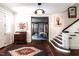Inviting foyer with dark stained hardwood floors, staircase and view into the living room at 117 Hillcrest Rd, Raleigh, NC 27605