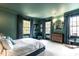 Stylish main bedroom with three large windows, soft carpet, and dark green wall paint at 117 Hillcrest Rd, Raleigh, NC 27605