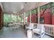 Enclosed porch with white furniture, views of exterior trees and surrounding property at 117 Hillcrest Rd, Raleigh, NC 27605