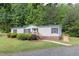 Inviting single-story home featuring accessible ramp, landscaped yard, and paved walkway at 1201 Red Sunset Pl, Siler City, NC 27344