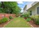 Grassy backyard with a wood fence, landscaping, and patio with seating at 1408 Fairmont St, Durham, NC 27713