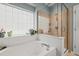 Bright bathroom showcasing a tub with glass block window and glass shower door at 1408 Fairmont St, Durham, NC 27713