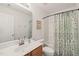Bathroom featuring a single sink vanity, toilet, and tub/shower combo with patterned curtain at 1408 Fairmont St, Durham, NC 27713