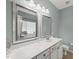 Bright bathroom featuring dual sinks, framed mirrors, and a window over the tub area at 1408 Fairmont St, Durham, NC 27713