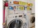 Well-organized laundry room with washer, dryer, shelving, cleaning supplies, and storage containers at 1408 Fairmont St, Durham, NC 27713