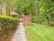 Lush backyard with walkway to private brick courtyard through an ornate, secured gate at 1428 Gray Bluff Trl, Chapel Hill, NC 27517