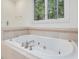 Large bathtub features tile surround, chrome fixtures, and a large window view at 1428 Gray Bluff Trl, Chapel Hill, NC 27517