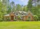 Stunning brick home featuring arched entry, manicured lawn, and mature trees at 1428 Gray Bluff Trl, Chapel Hill, NC 27517