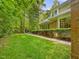A partial view of a house with a lush green lawn, mature trees, and a stone walkway at 1428 Gray Bluff Trl, Chapel Hill, NC 27517