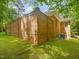 Exterior view of a brick house featuring an enclosed brick backyard wall and well-maintained lawn at 1428 Gray Bluff Trl, Chapel Hill, NC 27517