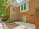 Exterior view of a brick home with a concrete patio and well-maintained landscaping at 1428 Gray Bluff Trl, Chapel Hill, NC 27517