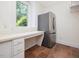 Bright kitchen features a stainless steel refrigerator, white cabinets and countertops, and a large window at 1428 Gray Bluff Trl, Chapel Hill, NC 27517