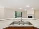 Bright kitchen featuring a stainless steel sink, white countertops, and a view of the fireplace at 1428 Gray Bluff Trl, Chapel Hill, NC 27517