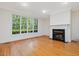 Cozy living room featuring a fireplace, a large window and gleaming hardwood floors at 1428 Gray Bluff Trl, Chapel Hill, NC 27517