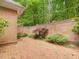 Brick patio with brick surround wall, lush landscaping and mature trees surrounding the perimeter at 1428 Gray Bluff Trl, Chapel Hill, NC 27517