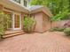 Large brick patio adjacent to the home with mature landscaping and mature tree surroundings at 1428 Gray Bluff Trl, Chapel Hill, NC 27517