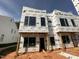 Exterior view of a new construction home with large windows and protective wrap at 1521 Sunrise Ave, Raleigh, NC 27608