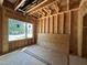 Unfinished room featuring exposed wooden framing, a window, and wood paneling on the floor at 1521 Sunrise Ave, Raleigh, NC 27608