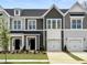 Charming new construction townhomes featuring gray siding, white trim, and inviting front yards at 158 Ripple Way # 321, Clayton, NC 27520
