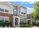 Attractive townhouse with a mix of stone and siding, complemented by manicured shrubs and flowering plants at 1710 Grace Point Rd, Morrisville, NC 27560